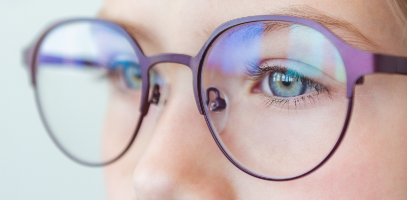 A close-up of a child wearing a pair of glasses.]
